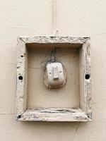 ancien interrupteur d'éclairage sur un mur de ciment. lumière naturelle. décentré photo