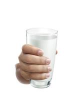 verre de lait sur les mains humaines. isolé sur fond blanc photo