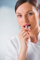 jeune femme dentiste médecin tenant le chewing-gum et souriant. photo