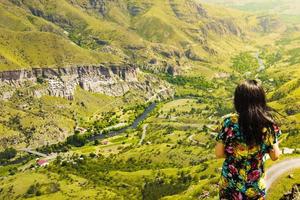 Une femme caucasienne profite d'une superbe vue panoramique sur le paysage de la ville et de la vallée de la grotte de vardzia photo