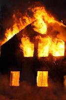 une maison en flammes avec des flammes qui sortent des fenêtres