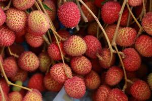 litchis fruits frais beaucoup d'entre eux sont vendus à la vente sur le marché. photo