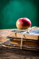 vieux livres et pomme sur le banc d'école