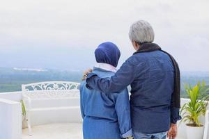 arrière du couple mature romantique voyant le paysage. mari embrasse sa femme. concept de couple de personnes âgées de bonheur. photo