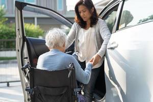 Une patiente asiatique âgée ou âgée, assise sur un fauteuil roulant, se prépare à aller à sa voiture, concept médical solide et sain. photo