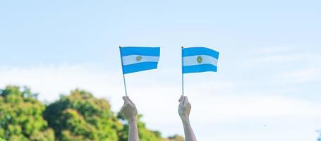 main tenant le drapeau argentin sur fond de nature. 9 juillet du jour de l'indépendance, 25 mai du jour de la révolution et concepts de célébration heureuse photo