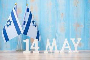 texte en bois du 14 mai avec des drapeaux israéliens. fête de l'indépendance d'israël et concepts de célébration heureuse photo