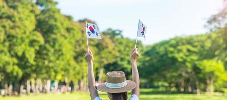 main de femme tenant le drapeau de la corée sur fond de nature. fondation nationale, gaecheonjeol, fête nationale nationale, jour de la libération nationale de la corée et concepts de célébration heureuse photo