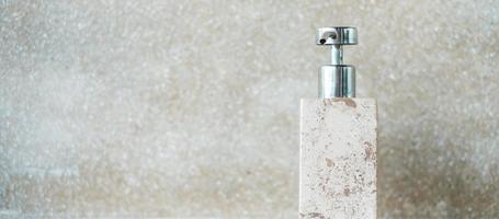 bouteilles d'articles de toilette dans la salle de bain d'un hôtel de luxe ou d'une maison moderne. gel douche pour le corps en céramique avec fond de mur photo