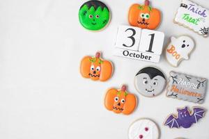 biscuits drôles d'halloween avec calendrier du 31 octobre sur fond blanc. truc ou menace, joyeux halloween, bonjour octobre, automne automne, concept festif, fête et vacances photo