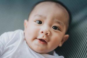 mignon petit bébé asiatique souriant et riant. bébé asiatique visage heureux et souriant. photo