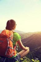 Backpacker femme profiter de la vue sur la falaise de pic de montagne
