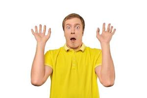 jeune homme effrayé avec les mains en l'air en t-shirt polo jaune, arrière-plan blanc isolé photo