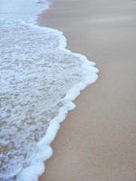 éclaboussure de vague blanche sur la plage de sable pour fond d'écran photo