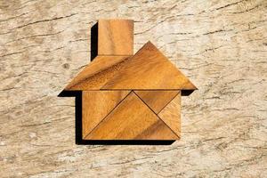 puzzle tangram en bois en forme de maison pour une maison de rêve ou un concept de vie heureuse photo