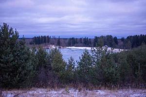 paysage d'été avec un beau lac avec des sapins et des montagnes boisées contre un ciel nuageux photo