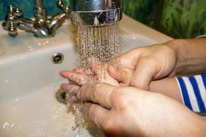 gros plan d'un homme caucasien et d'un enfant se lave les mains dans la salle de bain. prévention covid-19 photo