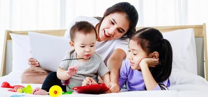 jeune mère asiatique en congé de maternité essayant de travailler en freelance avec un enfant en bas âge photo