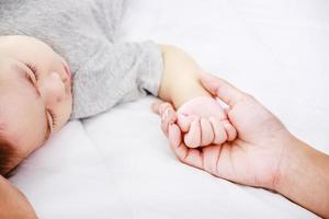 famille heureuse. maman tient la main de bébé. nouveau-né de famille heureuse. photo