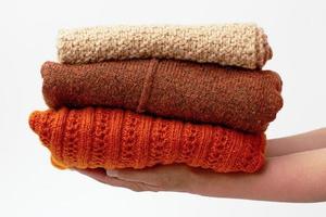 mains tenant une pile avec des vêtements en laine photo