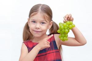enfant tenant une grappe de raisin photo