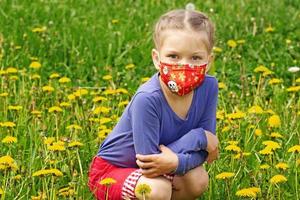 enfant masqué sur la pelouse de pissenlit photo