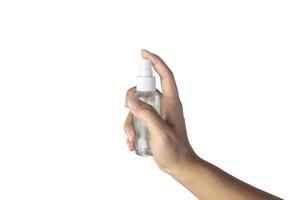 main de femme en appuyant sur le spray désinfectant pour la prévention des coronavirus sur fond blanc avec un tracé de détourage. photo