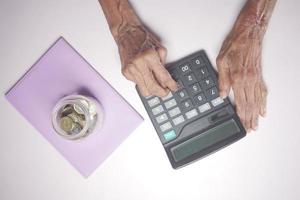 main de femmes âgées à l'aide de la calculatrice sur le bureau photo