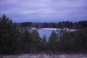 paysage d'été avec un beau lac avec des sapins contre un ciel nuageux photo