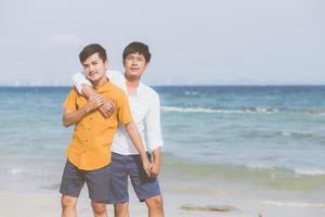 portrait homosexuel jeune couple asiatique debout câlin ensemble sur la plage en été, asie gay va tourisme pour les loisirs et se détendre avec romantique et bonheur en vacances en mer, concept lgbt. photo