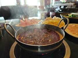 fondue chinoise avec bouillon épicé dans un bol sur la table photo