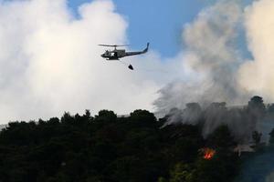 un hélicoptère des Nations unies éteint un incendie dans une forêt à la frontière israélo-libanaise. photo