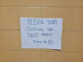 veuillez ne pas abuser du panneau de papier toilette sur le mur de la salle de bain photo