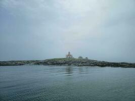 phare et rivage rocheux sur la côte du maine photo