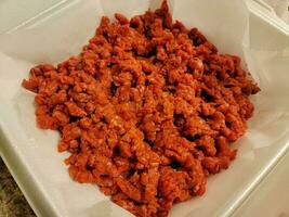 tas de viande de boeuf rouge crue moulue dans un récipient en mousse photo