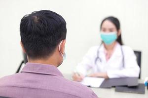 un patient asiatique consulte une femme médecin au sujet de sa santé et de ses symptômes photo