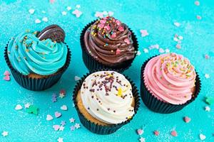 savoureux cupcakes colorés isolés sur fond bleu. délicieux petit gâteau photo