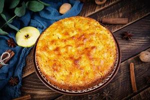 délicieuse tarte aux pommes maison sur fond de bois. tarte aux pommes avec ingrédients, pommes et cannelle photo