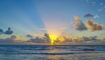 coucher de soleil coloré doré avec rayons de soleil plage tropicale tulum mexique. photo