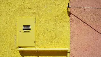 tuyau métallique et boîtier électrique sur mur de couleur jaune photo