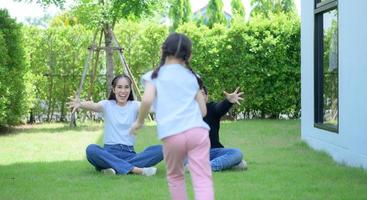 famille asiatique avec père, mère et fille s'amusant joyeusement dans le jardin de la maison