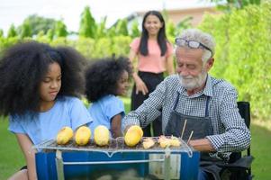 activités de vacances en famille avec grand-père, mère et enfants avec camping. barbecue grill et jouer dans la cour ensemble joyeusement en vacances. photo