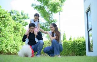 famille asiatique avec père, mère et fille s'amusant joyeusement dans le jardin de la maison photo