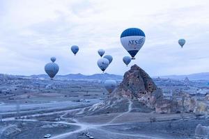 goreme, dinde, 2019- touristes chevauchant la montgolfière colorée qu'il survole goreme, paysage de cappadoce photo