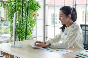 travail à domicile et concept d'apprentissage en ligne. de jolies jeunes femmes travaillant sur ordinateur regardent l'écran dans le salon ou l'espace de co-working. cours de formation en ligne pour étudiants. photo