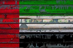 le drapeau national des émirats arabes unis est peint sur des planches inégales. symbole du pays. photo