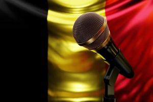 microphone sur le fond du drapeau national de la belgique, illustration 3d réaliste. prix de musique, karaoké, équipement de sonorisation de studio de radio et d'enregistrement photo