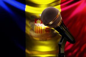 microphone sur le fond du drapeau national d'andorre, illustration 3d réaliste. prix de musique, karaoké, équipement de sonorisation de studio de radio et d'enregistrement photo