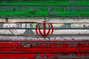 le drapeau national de l'iran est peint sur des planches inégales. symbole du pays. photo