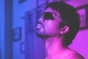 homme asiatique sur fond de studio bleu et rose en néon mixte photo